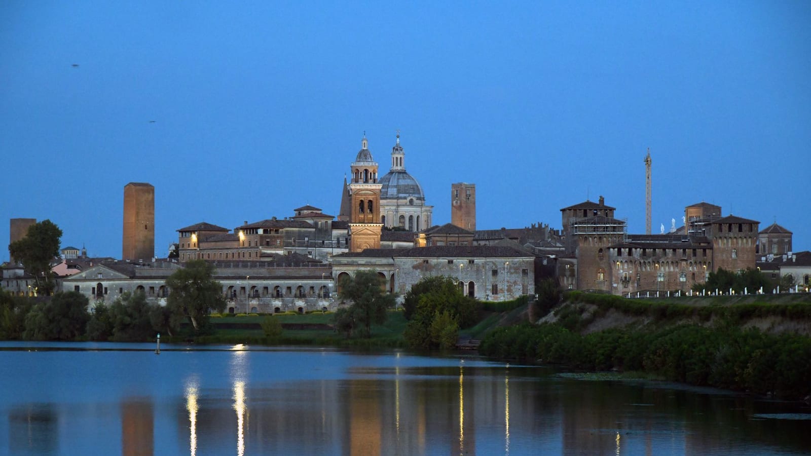 Lo skyline di Mantova riflesso sul lago al tramonto