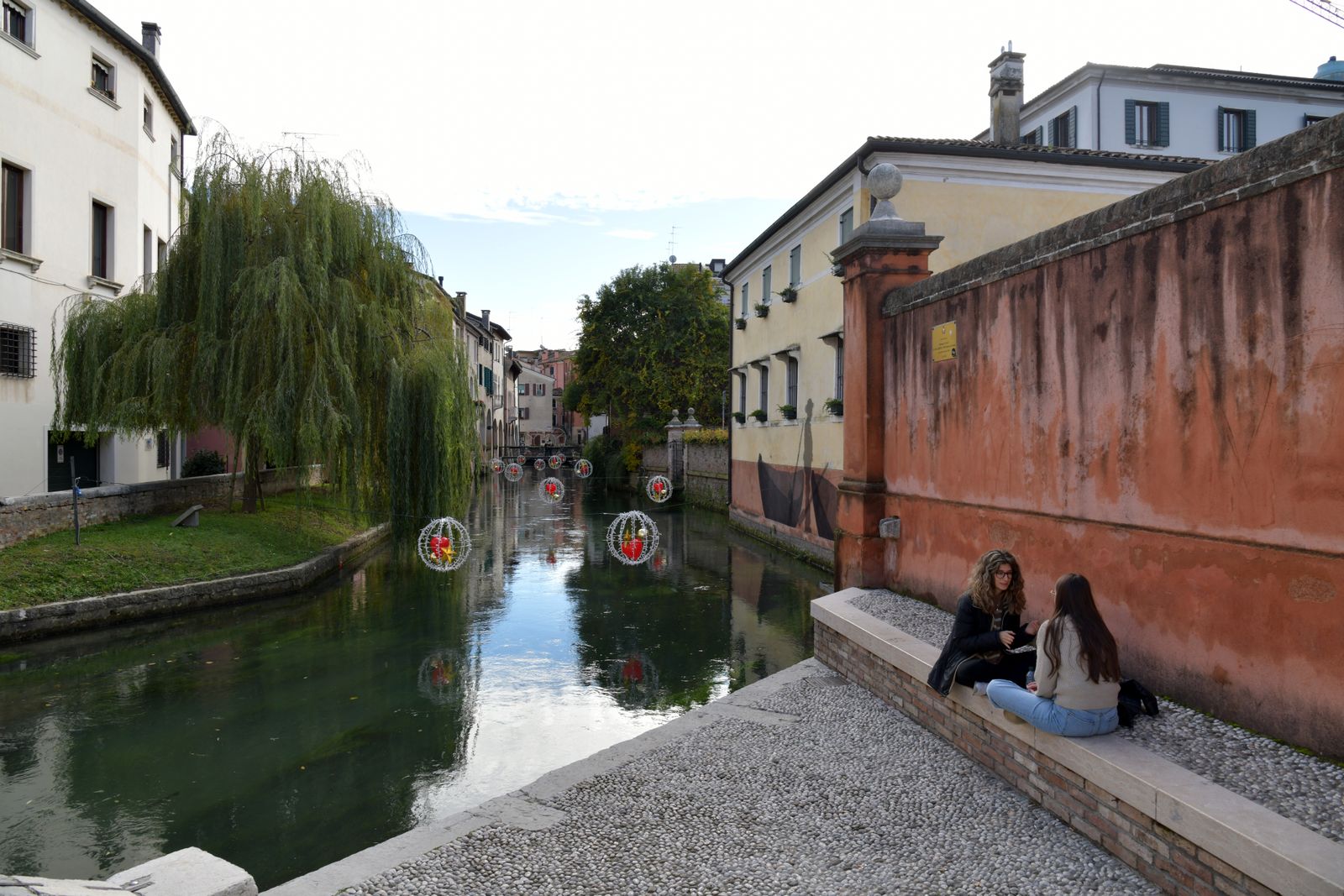 Un canale di Treviso con il salice e le decorazioni sull’acqua, nel centro storico