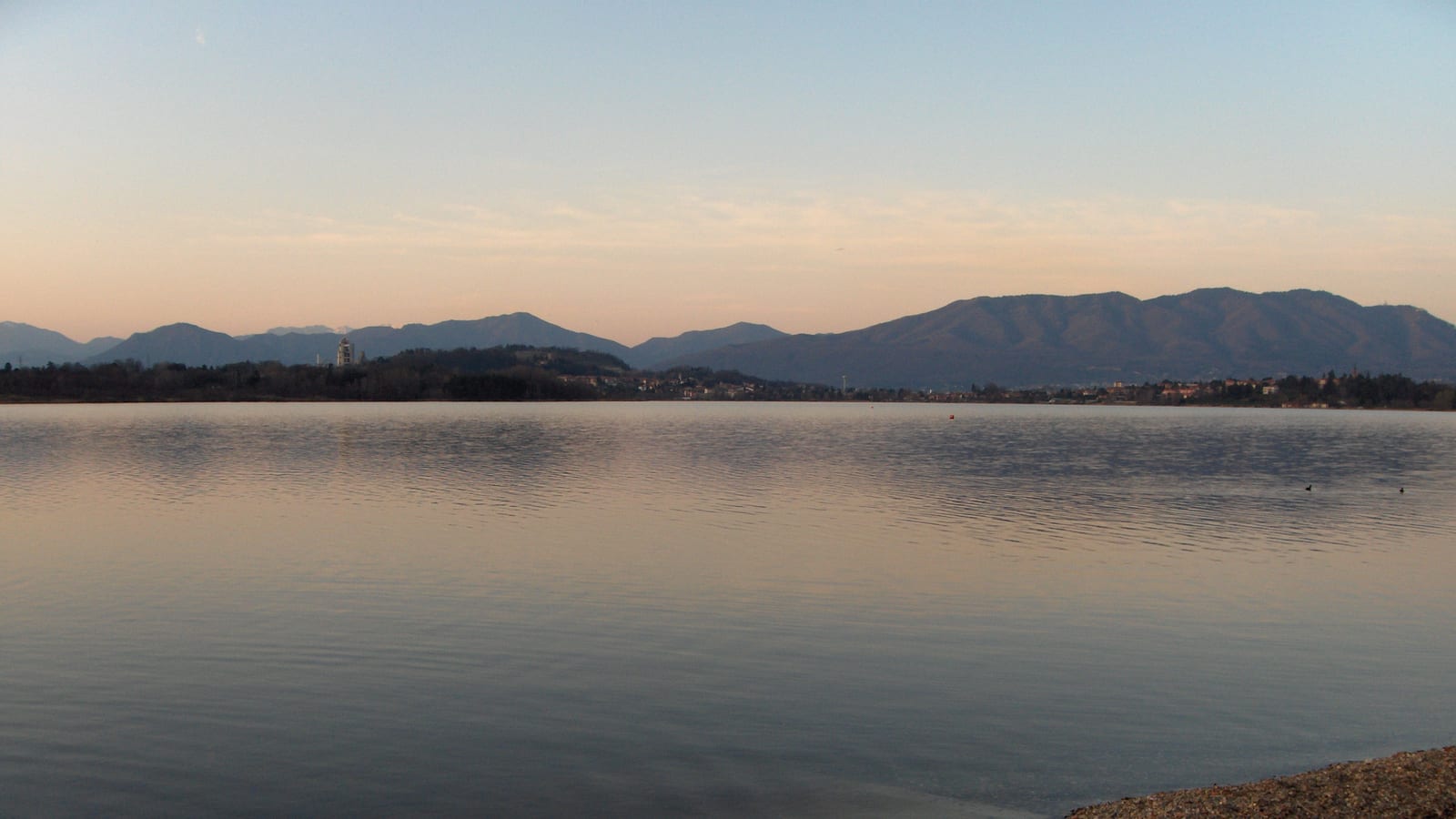 Un lago della provincia di Varese al tramonto, con le colline